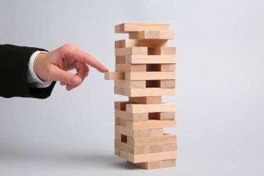 Açık gri arka planda Jenga oynayan kadın, yakın plan