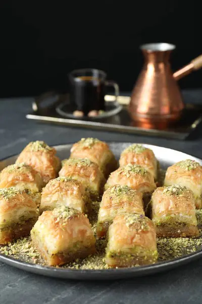 Delicious fresh baklava with chopped nuts on grey table. Eastern sweets