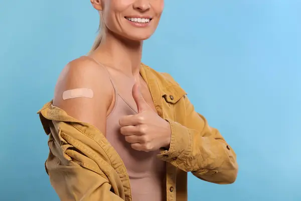 Aşıdan Sonra Kolunda Sargı Bezi Olan Gülümseyen Kadın Açık Mavi — Stok fotoğraf