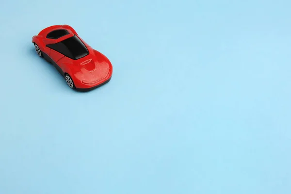 ライトブルーの背景にある赤い車 テキスト用のスペース 子供のおもちゃ — ストック写真