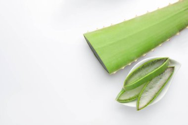 Beyaz arka planda kesilmiş aloe vera tabağı, düz. Metin için boşluk