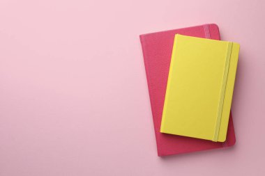 Açık pembe arkaplan ve üst manzara üzerine farklı not defterleri. Metin için boşluk