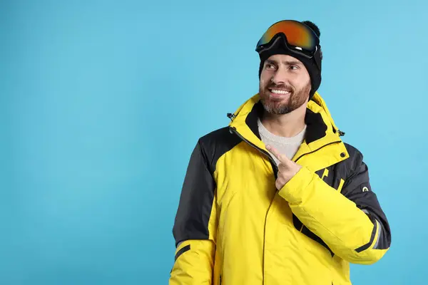 冬季运动穿着滑雪服 戴着浅蓝色背景护目镜的快乐男人 文字空间 — 图库照片