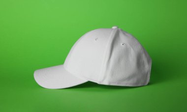 Açık yeşil zemin üzerinde şık beyaz beyzbol şapkası