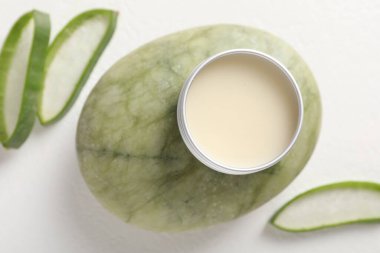 Beyaz arka planda dudak kremi ve aloe vera bitkisi.