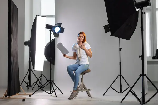 Casting call. Young woman with script performing on grey background in modern studio