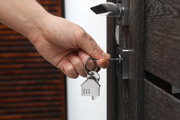 Man unlocking door with key, closeup view