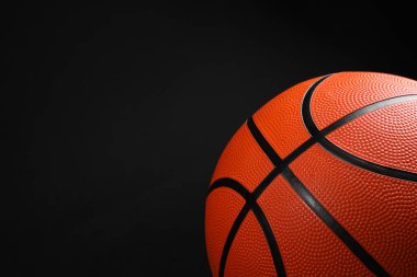 Siyah arka planda bir basketbol topu, yakın plan. Metin için boşluk