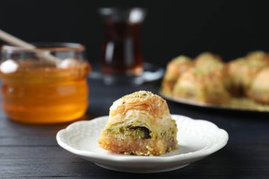 Siyah ahşap masada doğranmış fındıklı enfes taze baklava, yakın plan. Doğu tatlıları