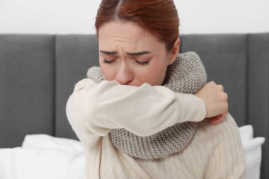 Yatakta öksüren eşarplı kadın. Soğuk belirtileri