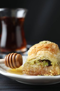 Lezzetli taze baklava, yanında doğranmış fındık ve bal, yakın plan. Doğu tatlıları