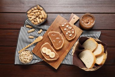 Lezzetli fındık ezmeli tostlar, muz dilimleri ve ahşap masada fıstıklar.