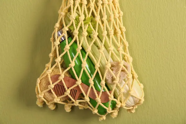 Bilinçli tüketim. Zeytin duvarında ekolojik ürünlerin asılı olduğu ağ çantası, yakın plan.