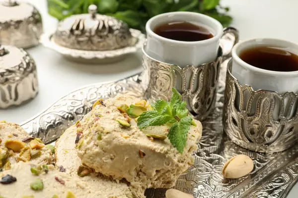 Beyaz masada servis edilen fıstıklı ve nane aromalı leziz helva.