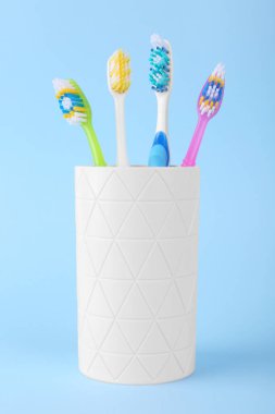 Açık mavi arkaplanda farklı diş fırçaları