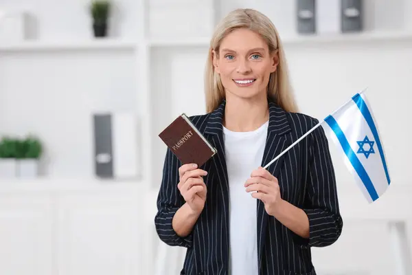 Immigration. Happy woman with passport and flag of Israel indoors, space for text