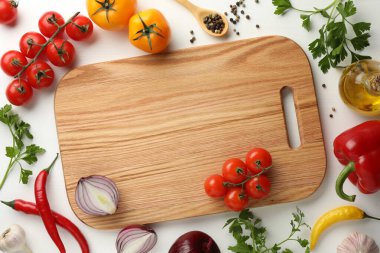 Tahta kesme tahtası, beyaz ahşap masa üzerinde sebzeli, düz yatıyordu. Metin için boşluk