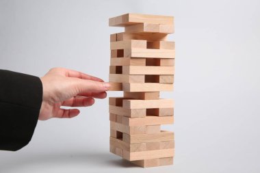 Açık gri arka planda Jenga oynayan kadın, yakın plan