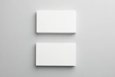 Açık gri arka planda boş kartvizitler, üst manzara. Tasarım için model