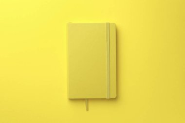 Sarı arkaplanda kapalı defter, üst görünüm