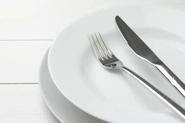 Καθαρά Πιάτα Πιρούνι Και Μαχαίρι Λευκό Ξύλινο Τραπέζι Closeup — Φωτογραφία Αρχείου