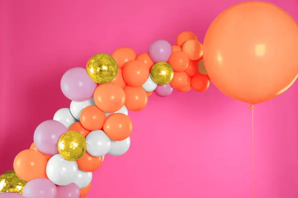 Balloon garland on pink background. Festive decor