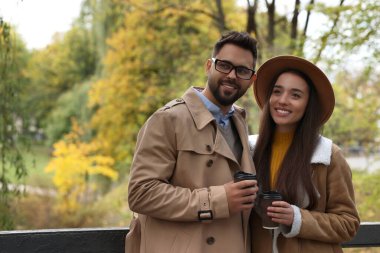 Romantik genç çift, sonbahar parkında birlikte vakit geçiriyorlar.