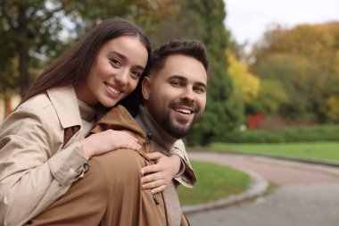 Romantik genç çift, sonbahar parkında birlikte vakit geçiriyorlar.
