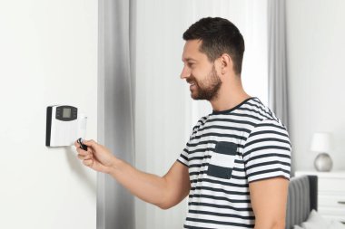 Ev güvenlik sistemi. Alarm anahtarı kullanan adam içeride.