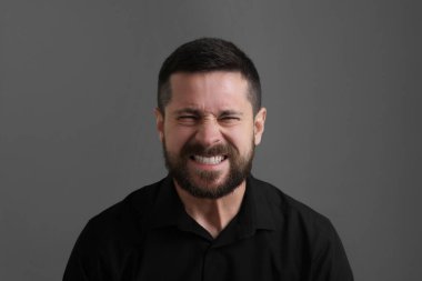 Kişilik konsepti. Gri arka planda kızgın bir adam.