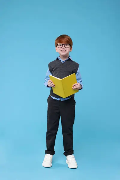 Estudante Sorridente Óculos Com Livro Sobre Fundo Azul Claro — Fotografia de Stock