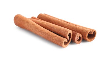 Beyaz üzerine izole edilmiş üç aromatik tarçın çubuğu.