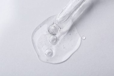 Beyaz arka planda kozmetik serumlu boru, üst görünüm