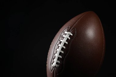 Siyah arka planda Amerikan futbol topu, yakın plan. Metin için boşluk