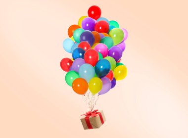 Bej arka planda hediye kutusuna bağlı bir sürü balon