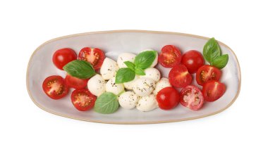 Domatesli lezzetli Caprese salatası, mozzarella, fesleğen ve baharatlar beyaza izole edilmiş.
