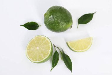Taze limonlu düz kompozisyon ve beyaz arkaplanda yapraklar