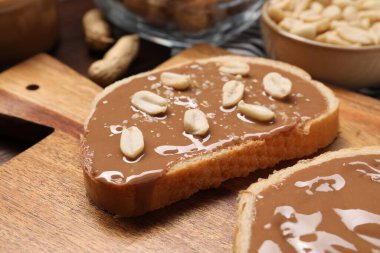 Lezzetli fındık ezmeli tostlar ve tahta üzerinde fıstık, yakın plan.