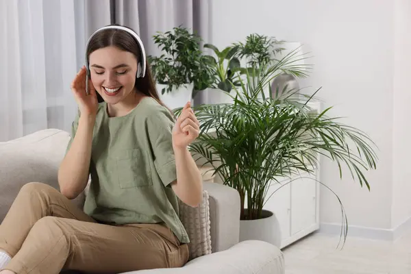 Όμορφη Νεαρή Γυναίκα Ακουστικά Ακούγοντας Μουσική Στον Καναπέ Στο Δωμάτιο — Φωτογραφία Αρχείου