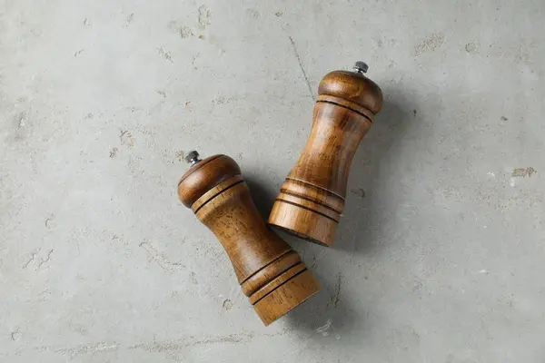 Wooden salt and pepper shakers on light textured table, top view