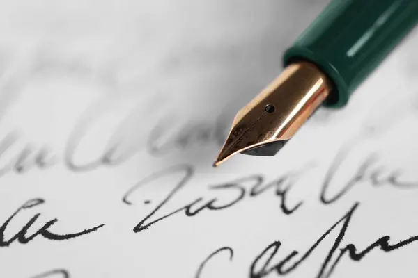 Elegant fountain pen on handwritten letter, closeup