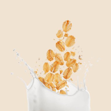 Yuvarlanan yulaflar bej arka planda süte dökülüyor.