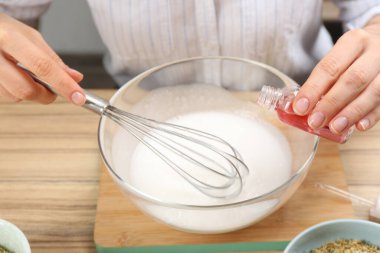 Ahşap masada doğal el yapımı sabun yapan kadın, yakın plan.