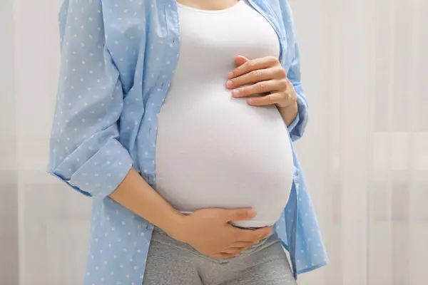 屋内で青いシャツで妊娠した女性 クローズアップ — ストック写真