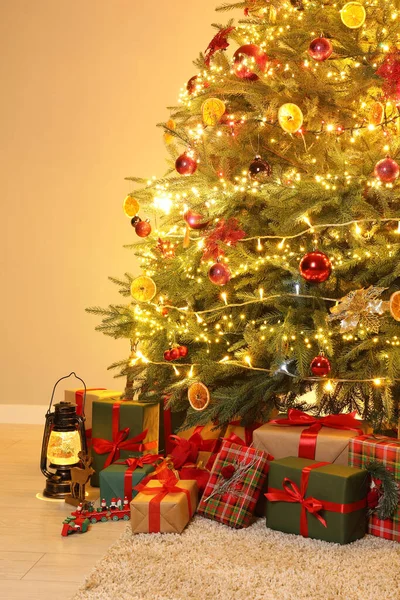 部屋の装飾やお祝いのライトで飾られたクリスマスツリーの下の多くのギフトボックス — ストック写真