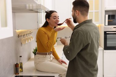 Genç ve güzel bir çift mutfakta birlikte yemek pişiriyor.