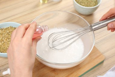 Ahşap masada doğal el yapımı sabun yapan kadın, yakın plan.