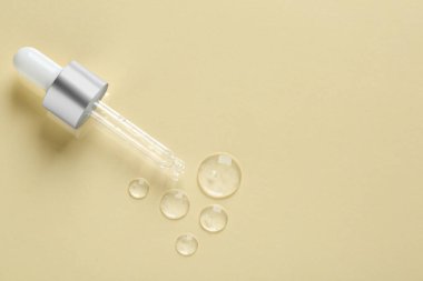 Bej arka planda kozmetik serumu numuneleri olan bir boru. Metin için boşluk