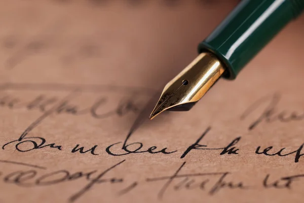 Elegant fountain pen on handwritten letter, closeup