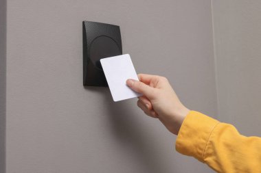 Kadın manyetik kapı kilidini anahtar kartıyla açıyor, yakın plan. Ev güvenliği